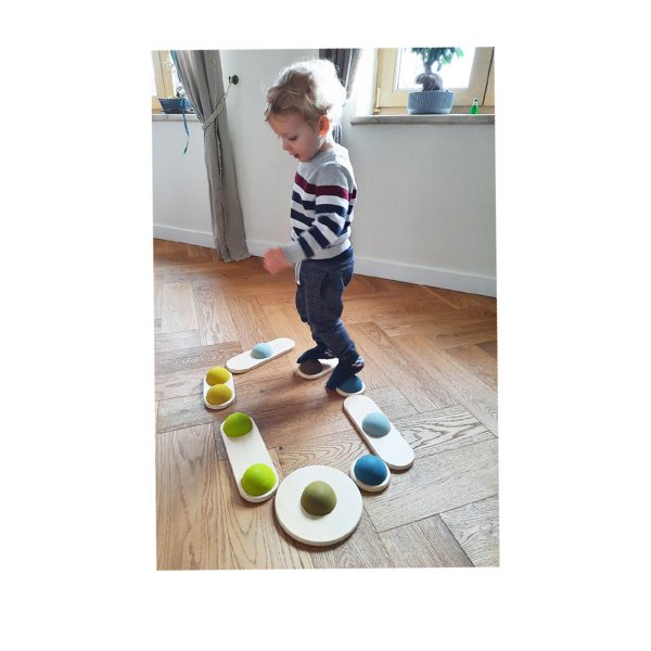 Kind balanciert über einen Parkour von Balanciersteinen